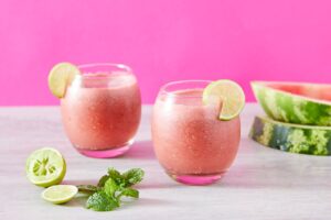 Two glasses of watermelon lime smoothies with mint, perfect for summer refreshments.